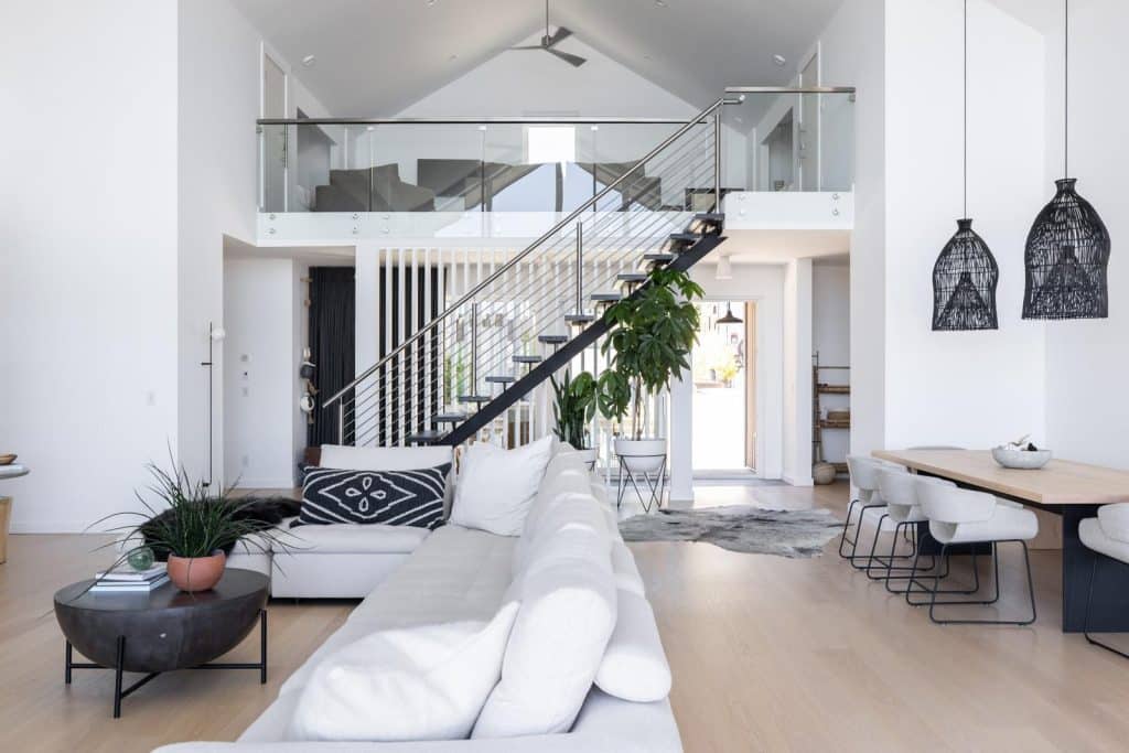 Bright modern home that features stairs with horizontal rod railings with glass standoff railings overlooking the landing. 