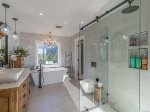 A luxurious bathroom with freestanding tub and seperate shower with a frameless sliding glass shower door. 
