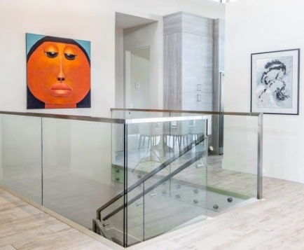 glass railings in a modern home with interesting art