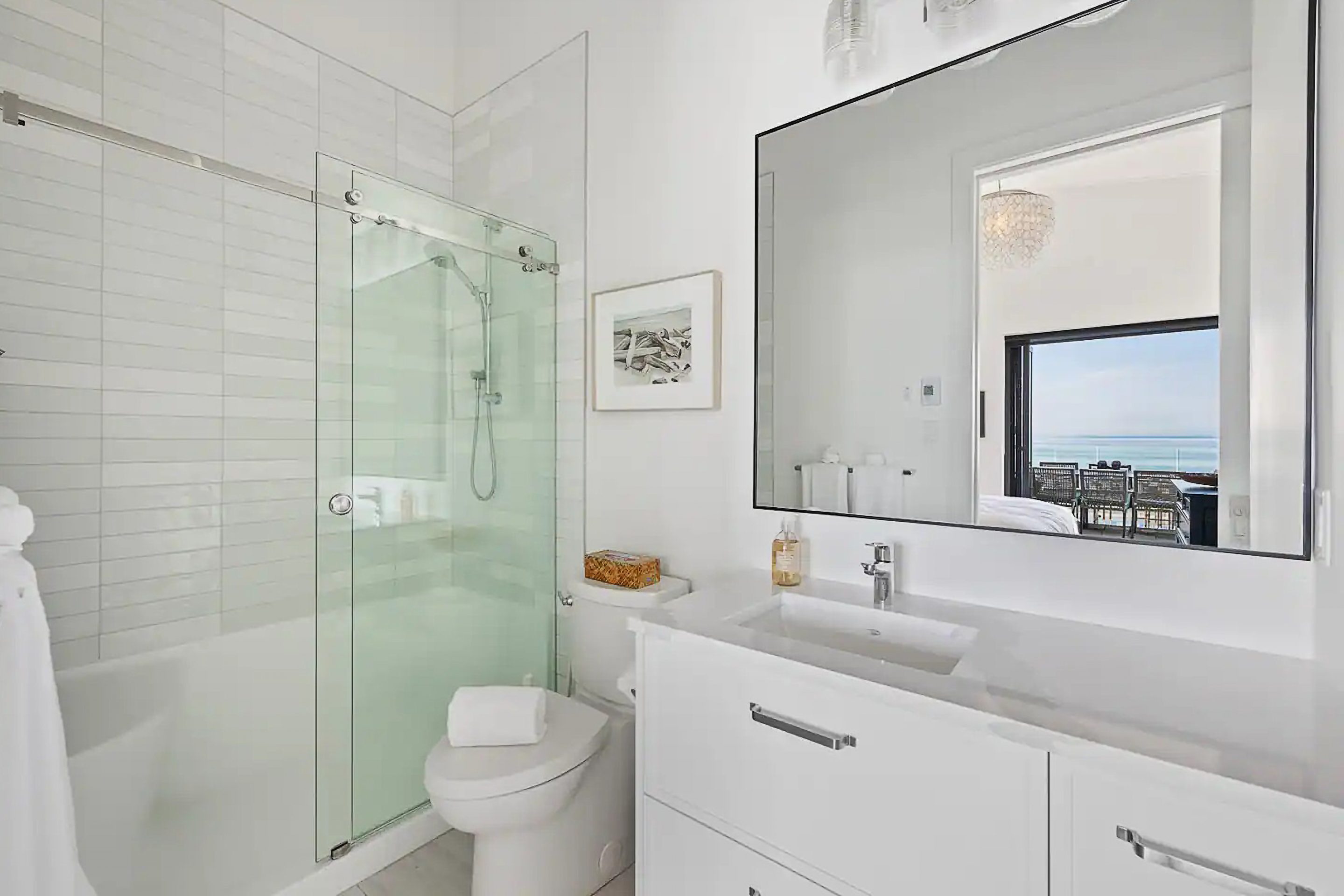 Black tiled shower with glass wall, with wood bench, plant, and separate tub.